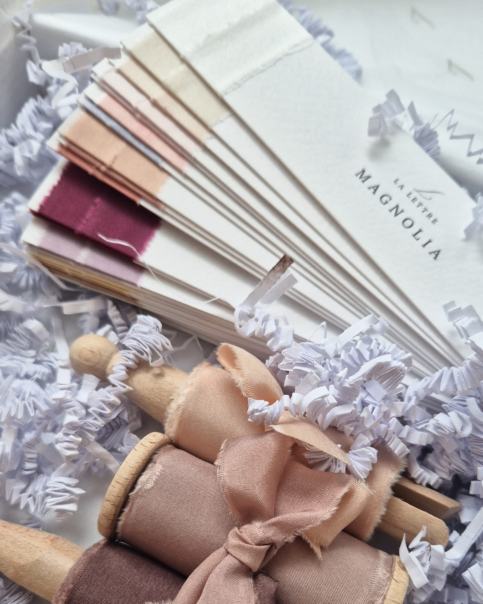 La Lettre Lint kleurenwaaier in een doos met handgeverfde zijden linten op houten spoeltjes in crème, roze en warme bruintinten.